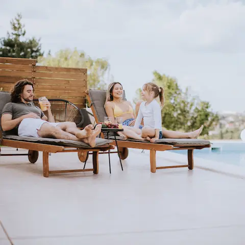 family on concrete deck by pool