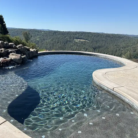 freeform pool featuring rock work plus a view
