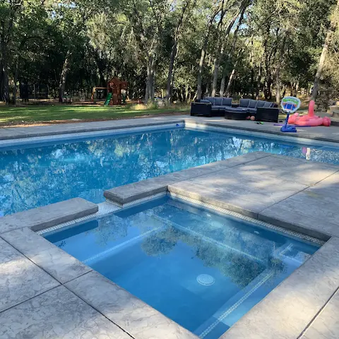 in ground geometric pool with attached in ground hot tub spa
