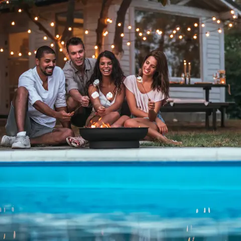 Enjoying time together poolside by backyard swimming pool
