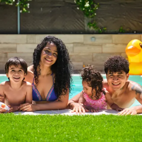 Family enjoying swimming pool in their back yard