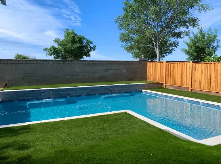 L-shaped in ground concrete gunite pool with sheer descent water features